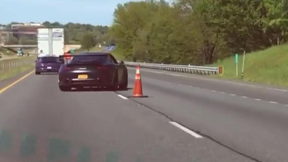 Porsche 911 zigzagt tussen pylonen op snelweg