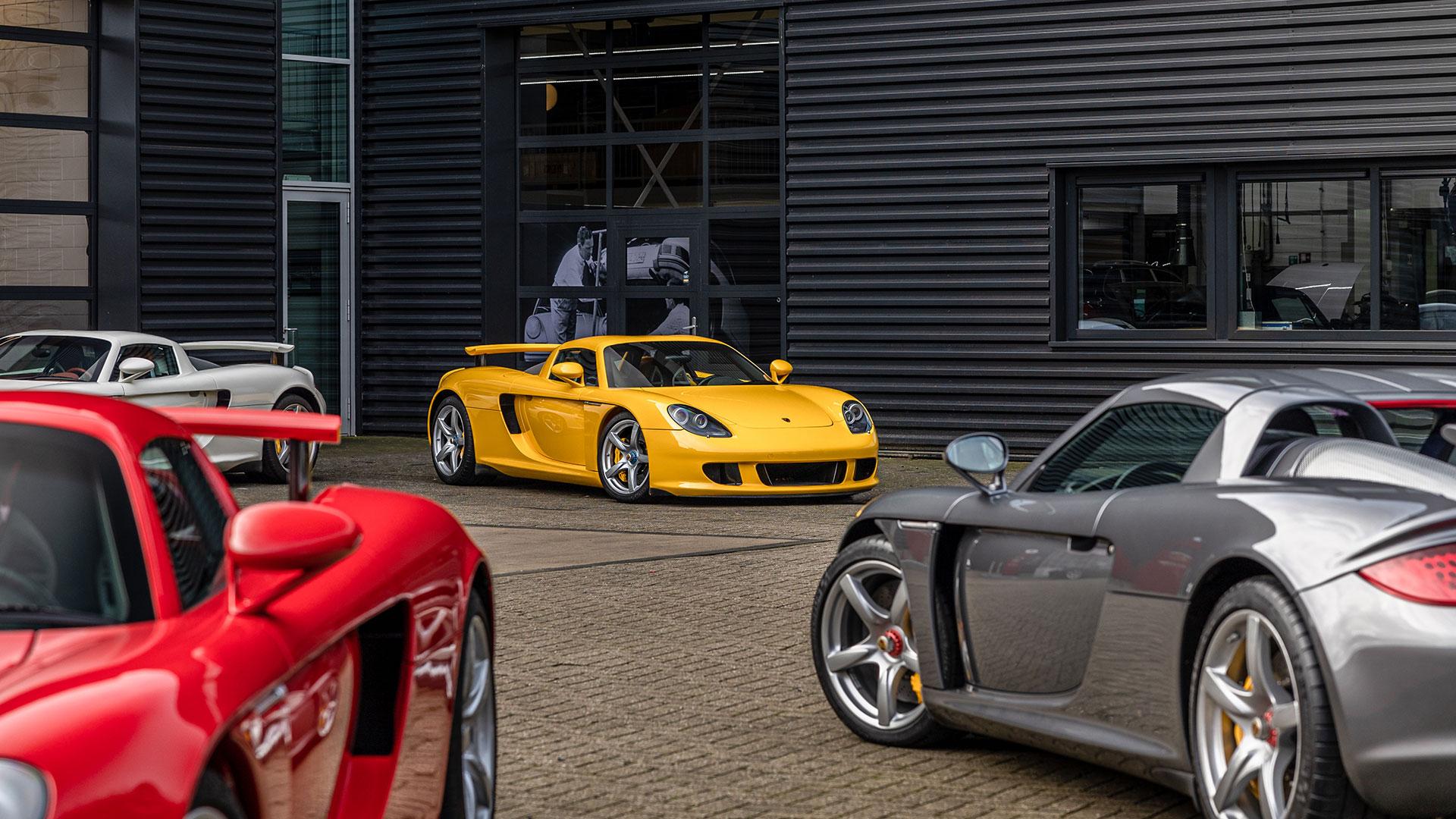 Vijf Porsche Carrera GT's in de kleuren rood, geel, zwart, wit, en grijs