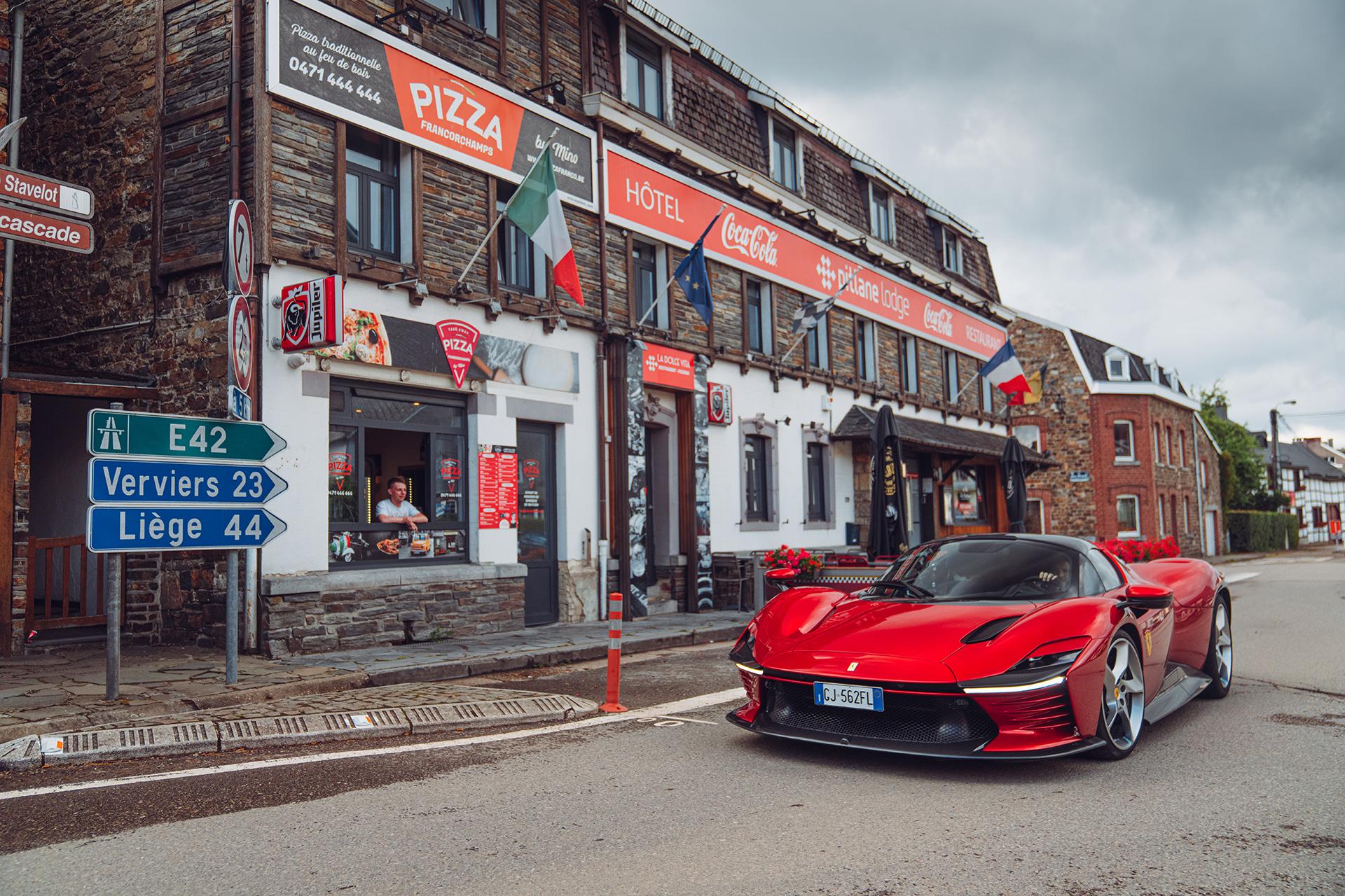Ferrari Daytona SP3 rijdend in een Vlaams dorpje met borden richting Verviers en Liège (Luik)