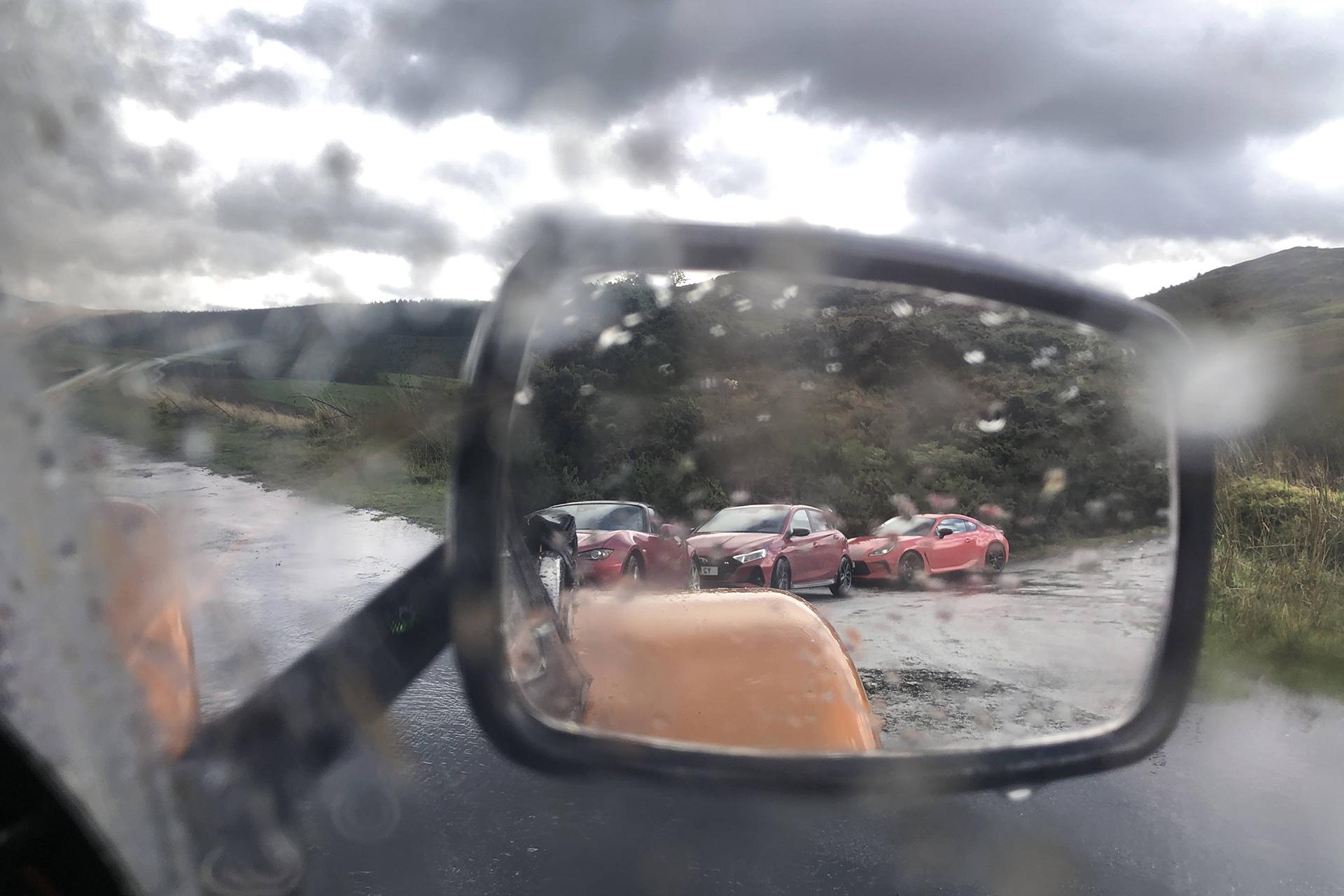 Betaalbare roadtrip regen op de buitenspiegel van de Caterham 170R