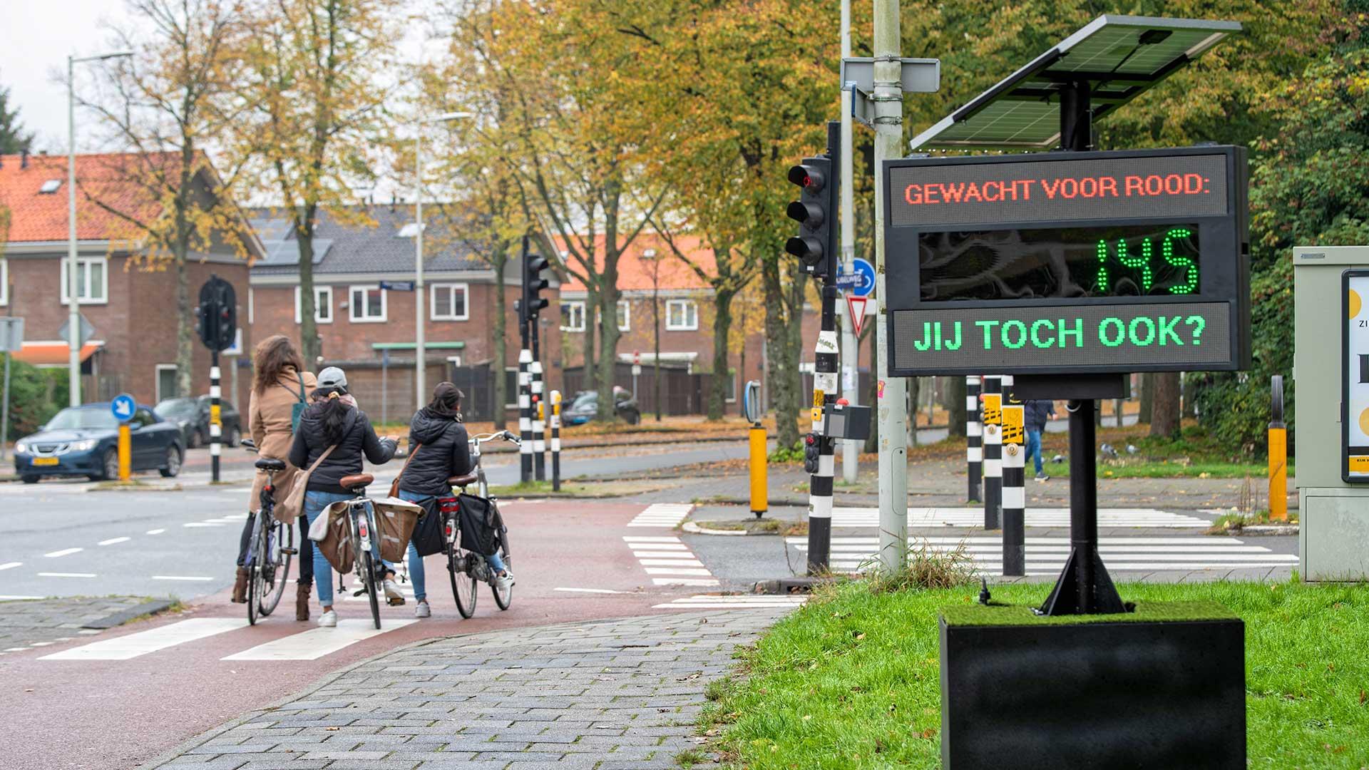 gestopt-voor-rood-teller bord met fietsers die stoppen voor rood in Amsterdam