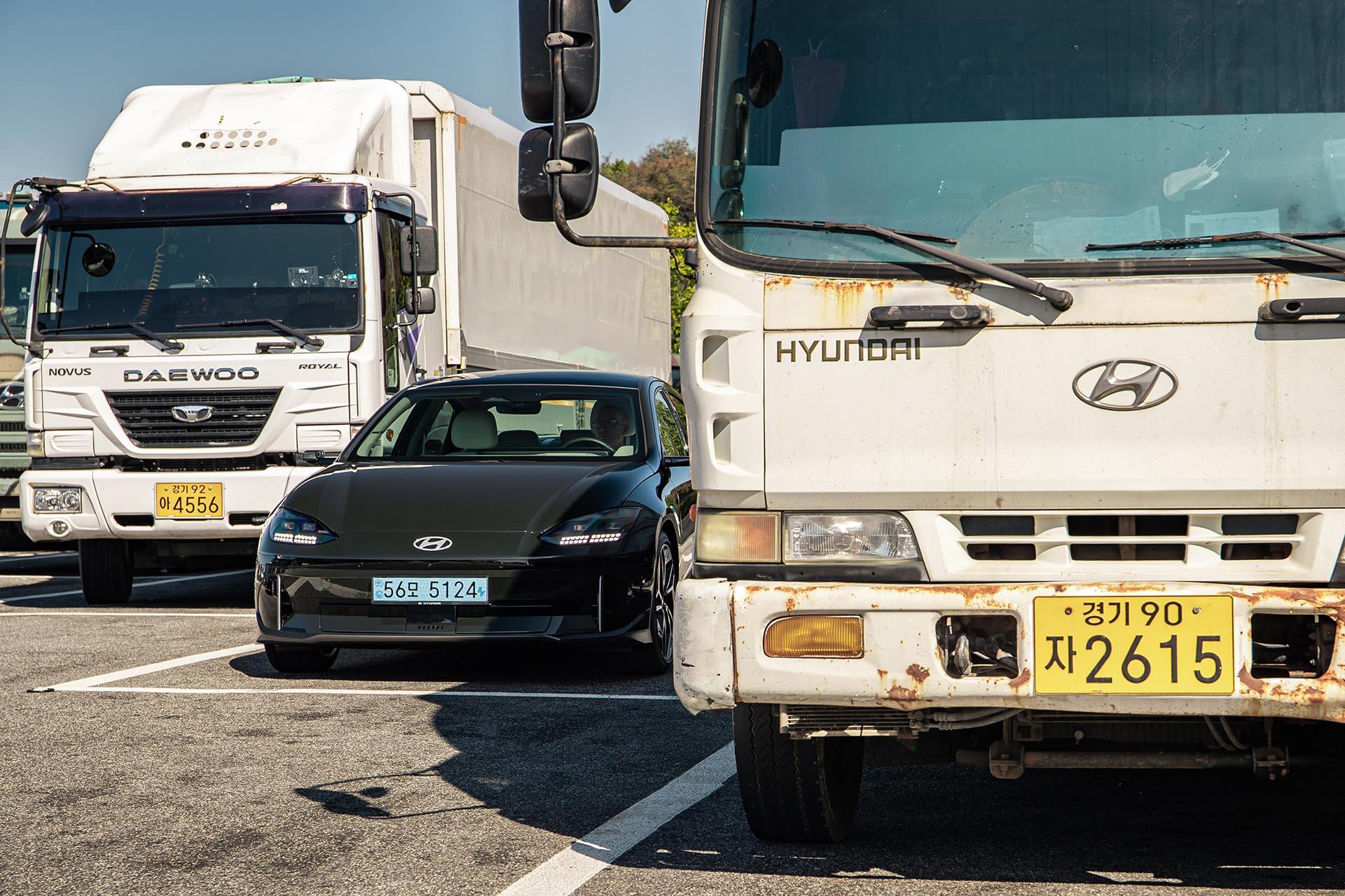 Hyundai Ioniq 6 geparkeerd tussen twee vrachtwagens
