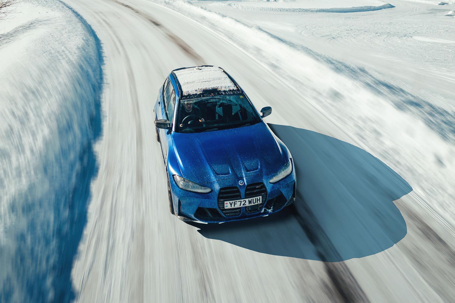BMW M3 Touring rijdend voorkant van boven in de sneeuw