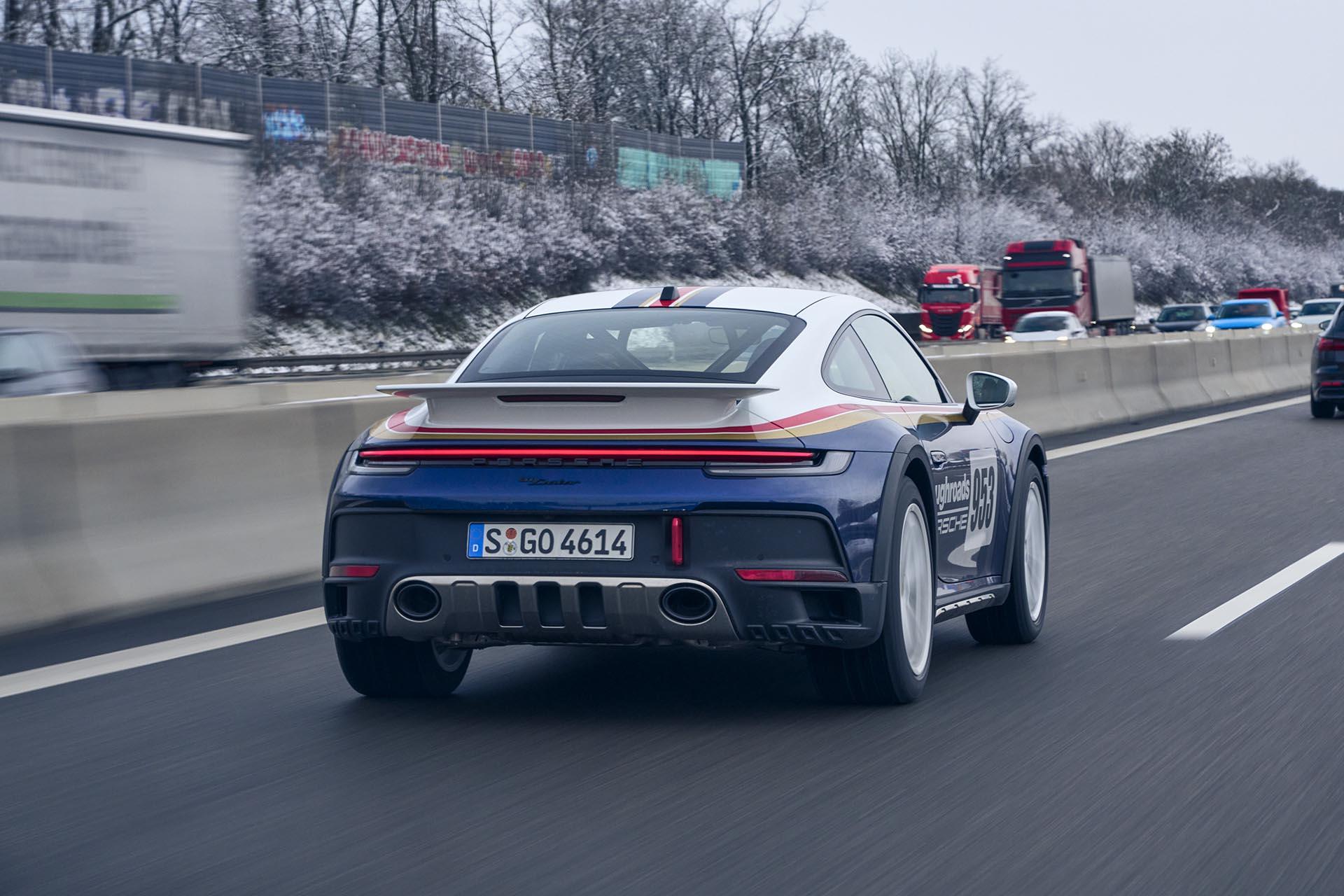 Porsche 911 Dakar rijdend schuin achter op de Autobahn