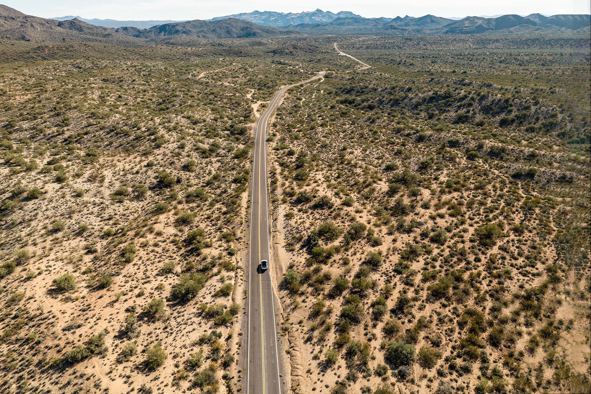 GMC Hummer EV rijdend in de woestijn van boven drone shot