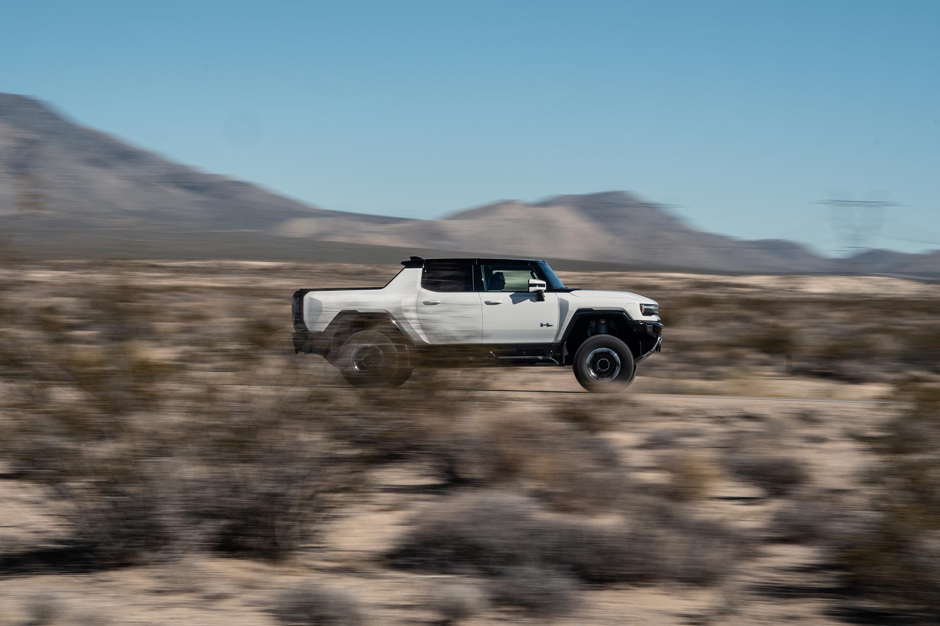 GMC Hummer EV rijdend zijkant woestijn