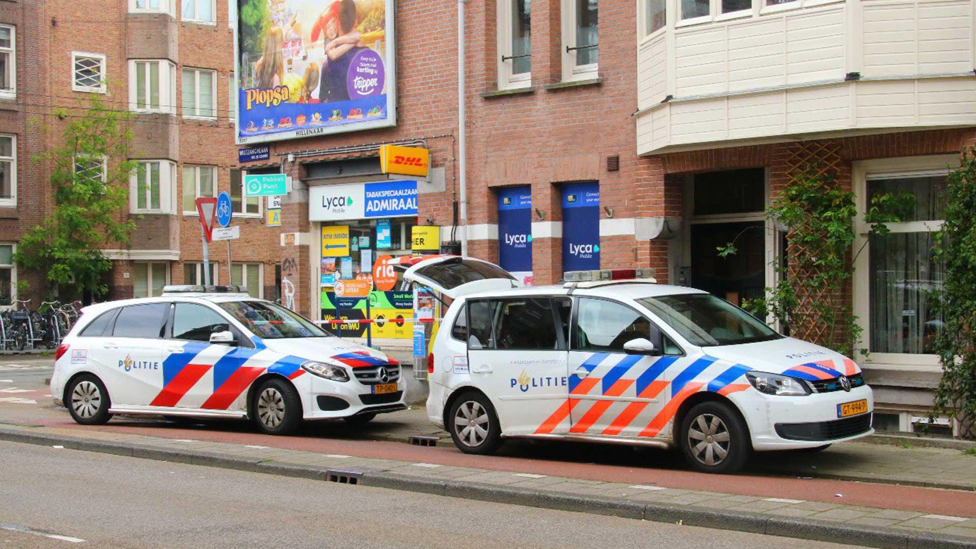 Twee Nederlandse politieauto's geparkeerd achter elkaar zijkant Amsterdam