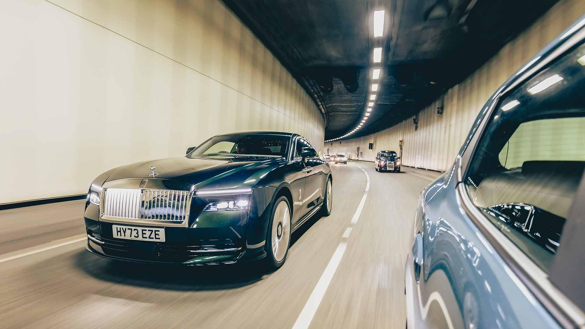 Rolls-Royce Spectre rijdend schuin voor tunnel