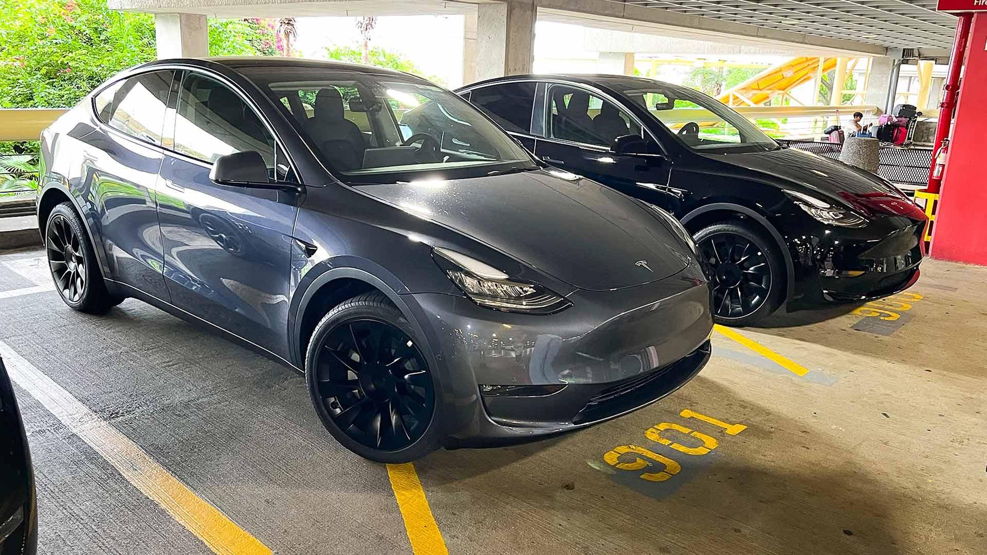 Tesla Model Y geparkeerd schuin voor parkeergarage