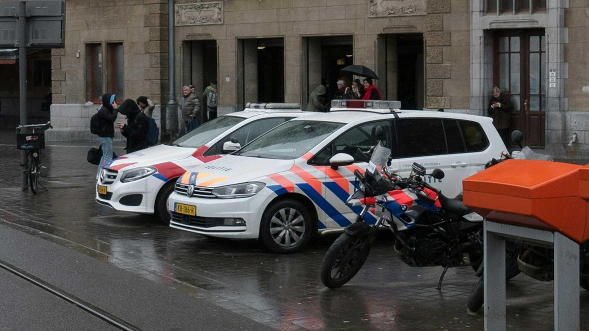 Politieauto's in Amsterdam bij het station. Mercedes B-klasse en Volkswagen Touran