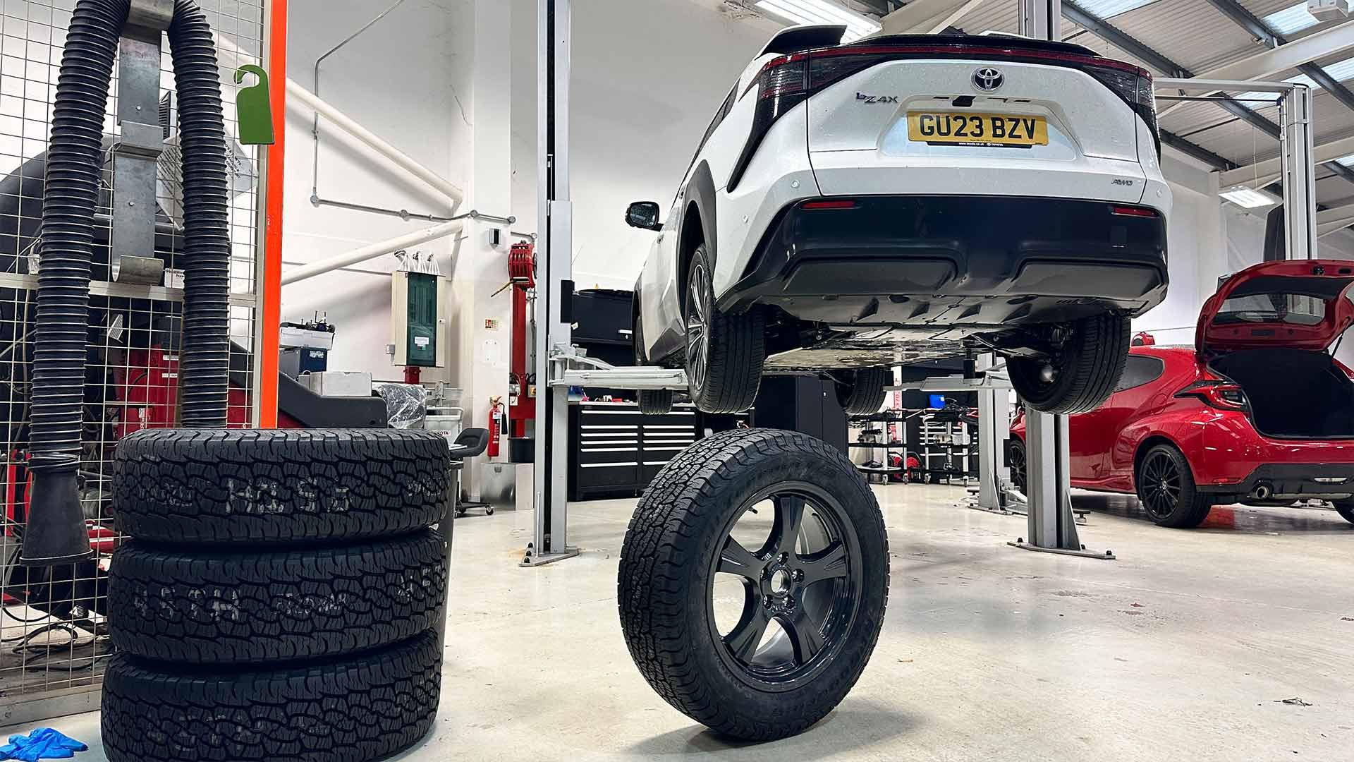 Toyota bZ4X schuin achter bij monteur garage op de brug banden wielen