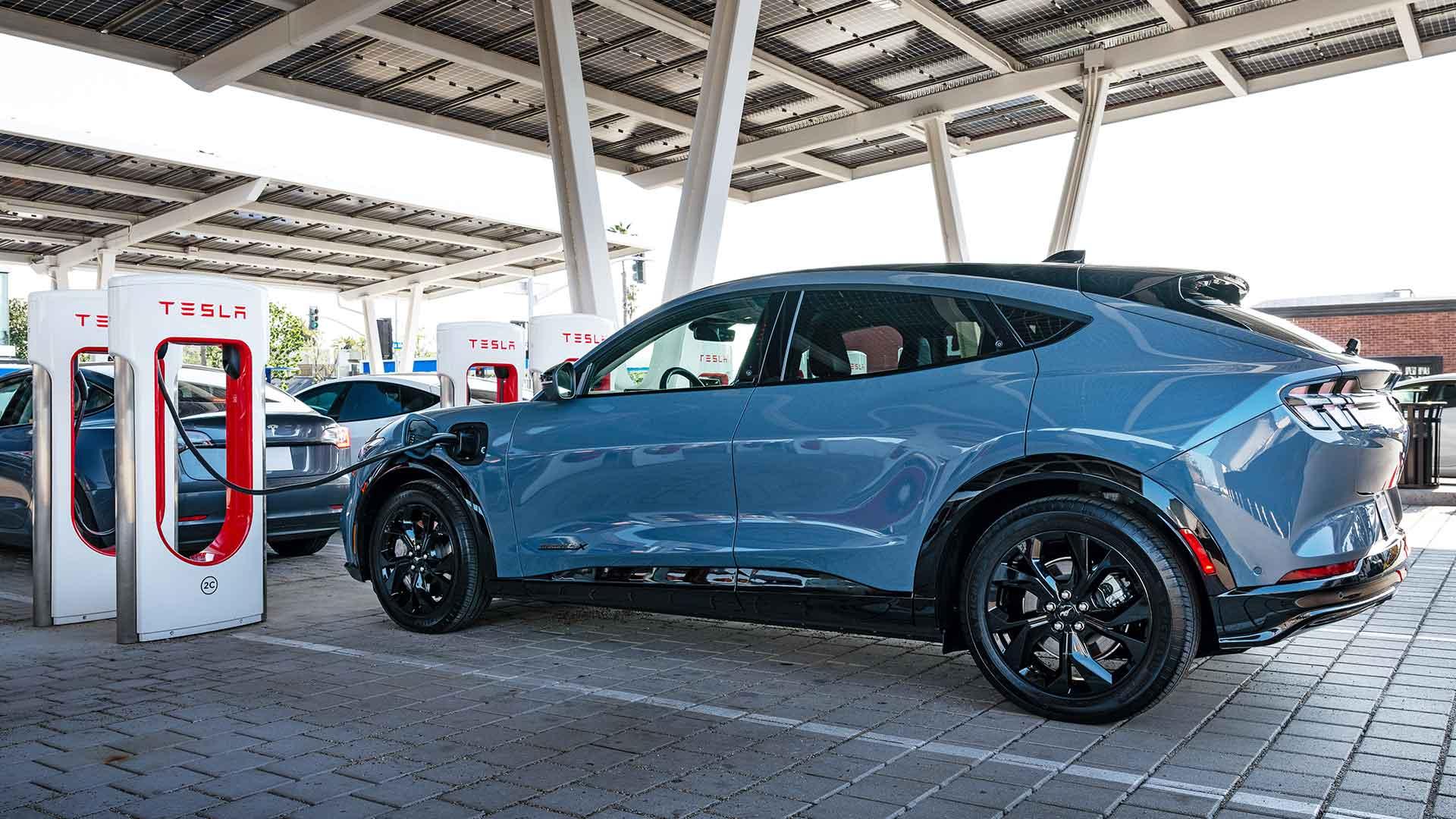 Ford Mustang Mach-e aan het opladen bij een Tesla Supercharger