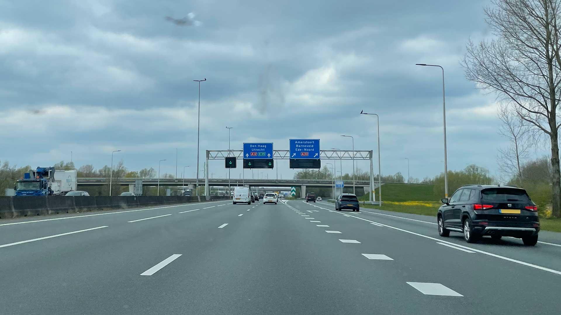 Snelweg A12 richting Den haag. Spitsstrook met groene pijl en afrit A30