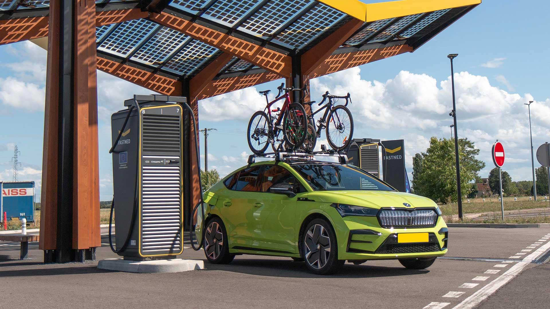 Skoda Enyaq at the charging station with bicycles on the roof (fastned) along the highway