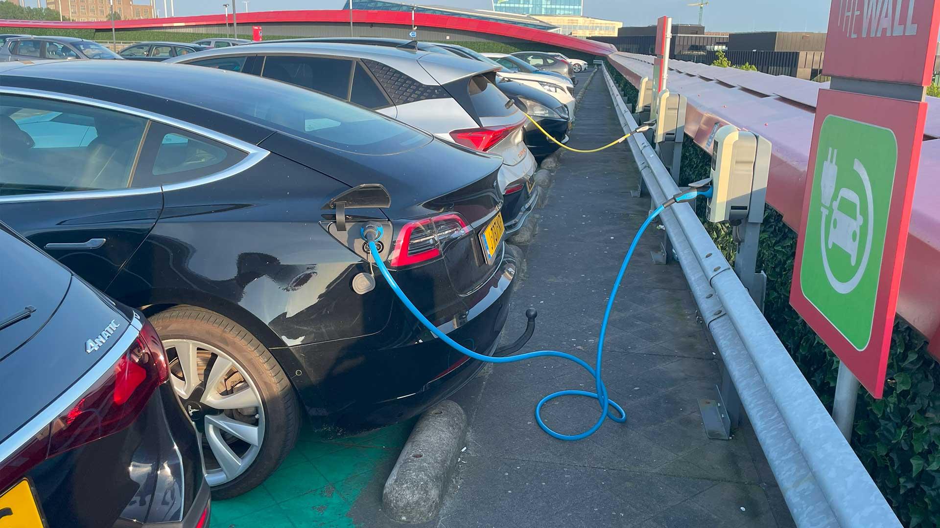 Tesla Model 3 en Cupra Born aan de laadpaal met snoer (stekker) elektrische auto