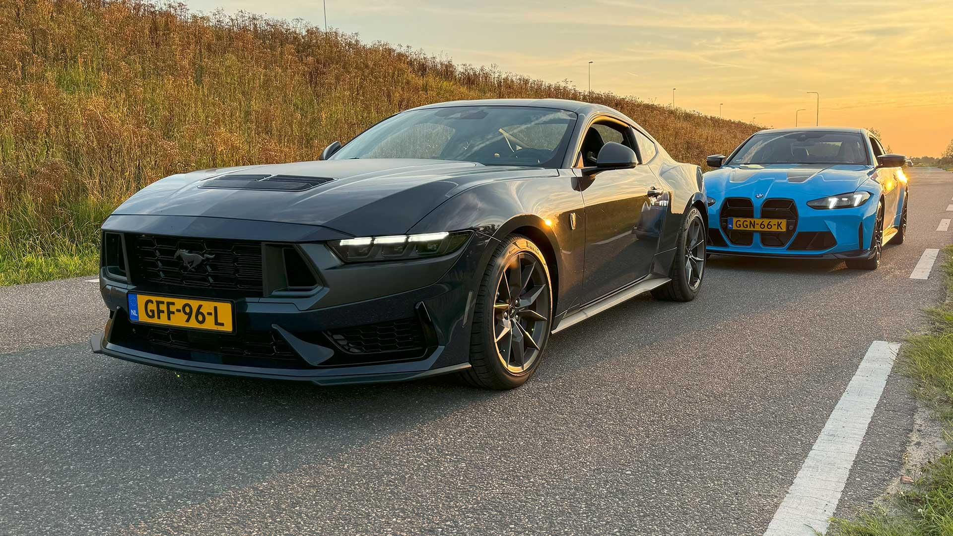 Ford Mustang Dark Horse op Nederlands kenteken bij zonsondergang met BMW M4 CS in blauw