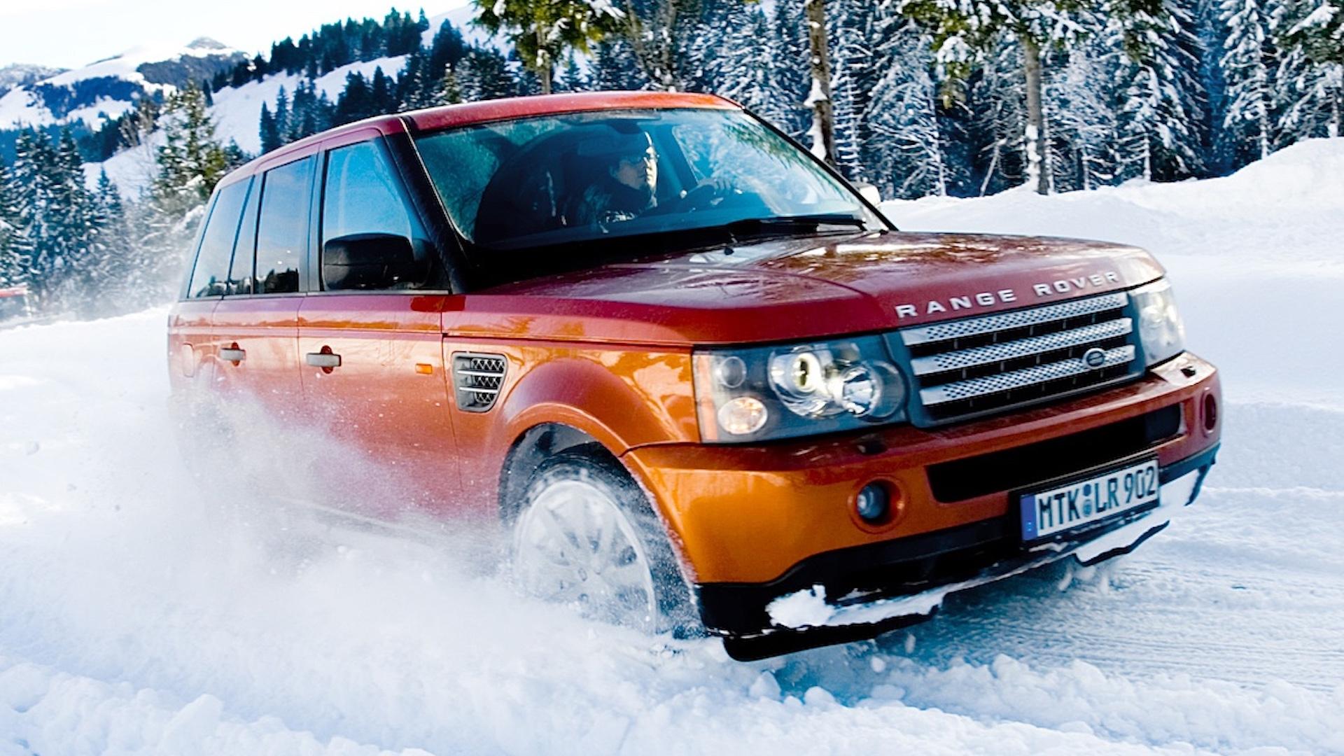 Land Rover Range Rover Sport Supercharged (L320) oranje (2005) zijkant voor sneeuw rijdend schuin rechts