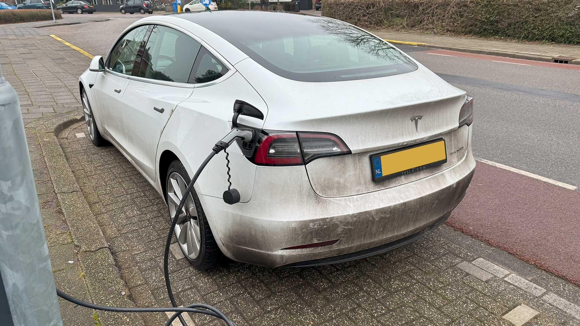 Vieze Tesla Model 3 aan de laadpaal