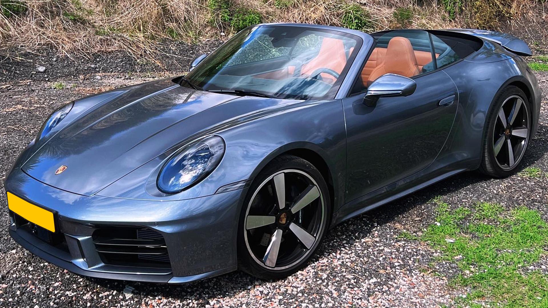 Porsche 911 Carrera Cabriolet (992) Vanadium Grijs (2025) zijkant rechtsvoor schuin dak omlaag