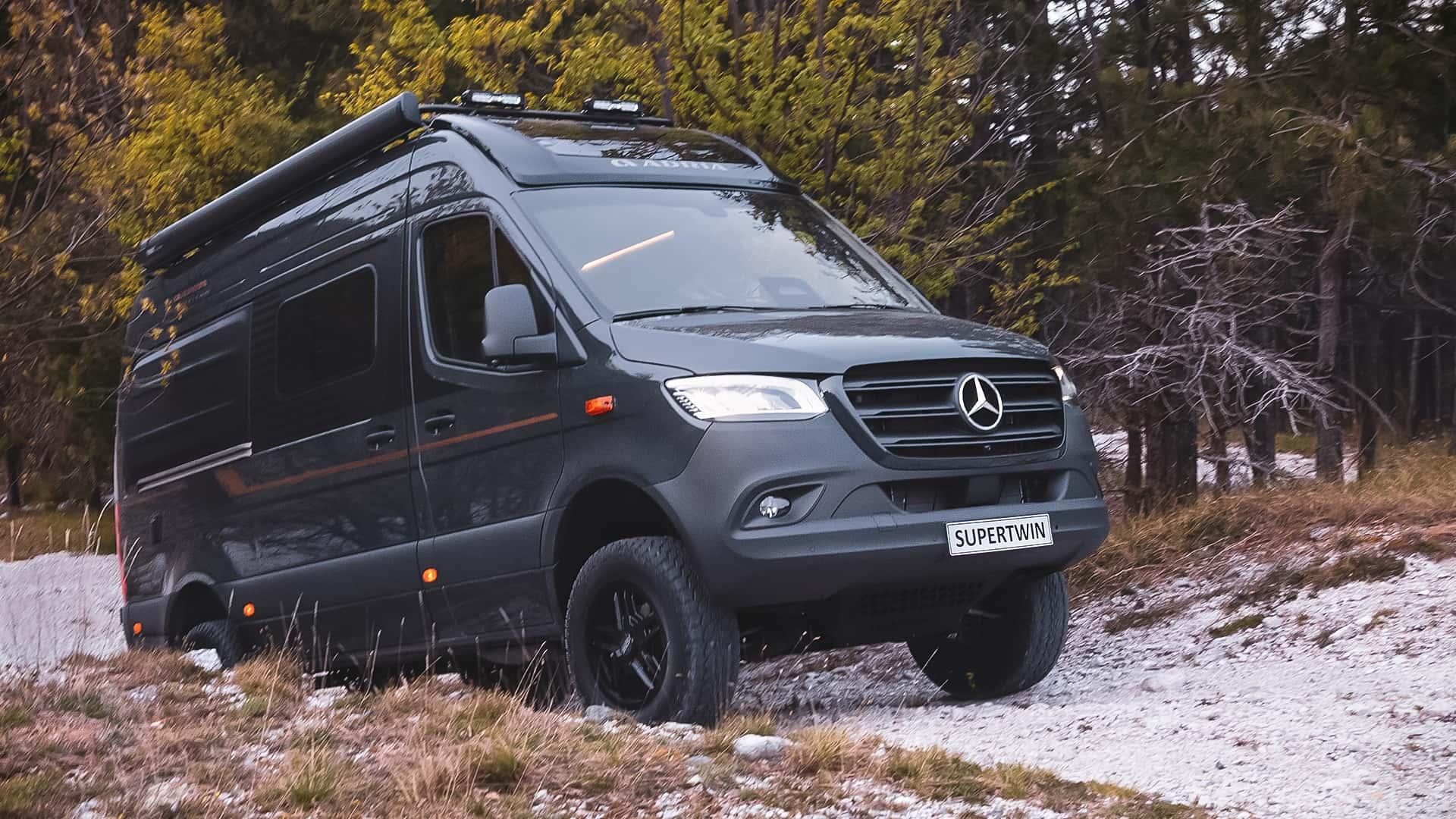 Adria Supertwin 4x4 (2024) zwart zijkant rechts schijn voor klimmend op stenen