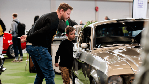 Vader en zoon bekijken Mustang autobeurs