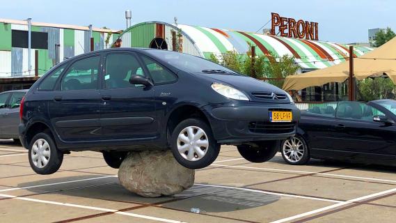 Auto parkeert op steen in Amsterdam