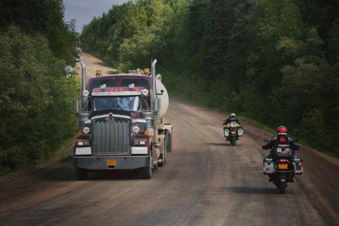 Kenworth-vrachtwagen op onverhard met motorrijders