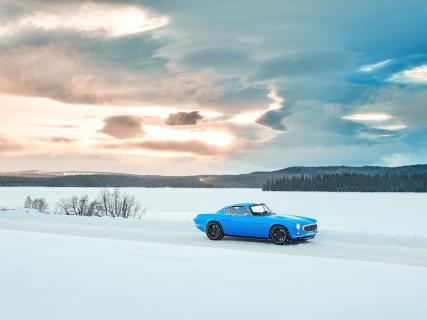 Volvo P1800 Cyan bij zonsondergang in de sneeuw
