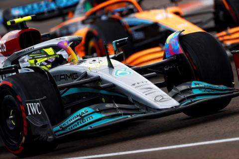 Lewis Hamilton in de Mercedes W13 met McLaren op de achtergrond