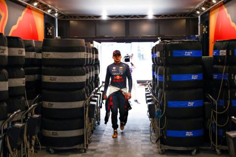 Max Verstappen tussen bandenstapels in de garage