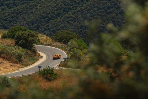 McLaren Artura rijdend op een weg door bergen ver weg