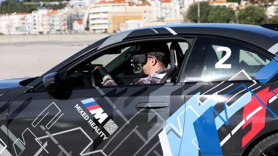 BMW M2 Mixed Reality rijdend zijkant man met VR-bril op met het raam naar beneden