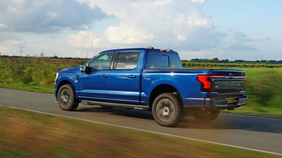 Ford F-150 Lightning rijdend op een weg schuin achter