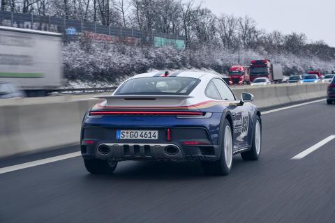 Porsche 911 Dakar rijdend schuin achter op de Autobahn