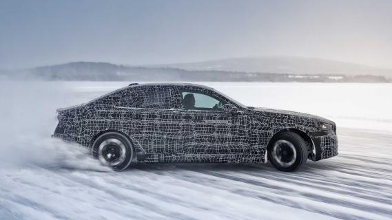 BMW i5 testauto driftend op een bevroren meer zijkant