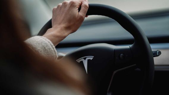 Tesla stuur hand op het stuur (Unsplash)