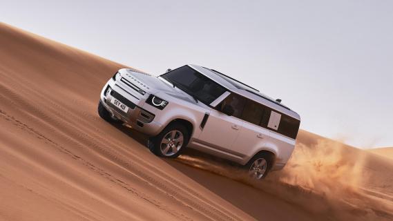 Defender 130 X-Dynamic HSE P400 MHEV (Land Rover) 3/4 voor rijdend zand woestijn offroad