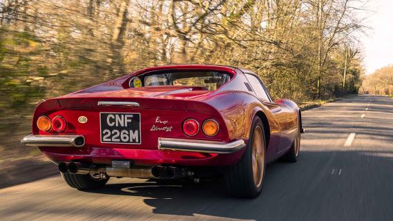 Ferrari Dino restomod rijdend schuin achter