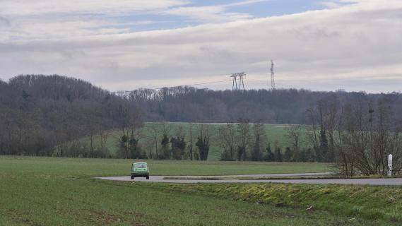 Originele Renault 5 rijdend voorkant landschap ver weg