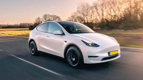 Tesla Model Y Nederlands kenteken rijdend schuin voor