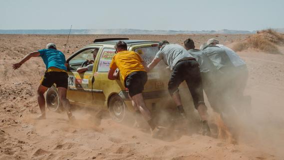 Twing Raid Renault Twingo rally auto's rijdend schuin achter vast in zand duwen