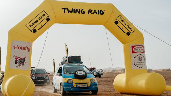 Twing Raid Renault Twingo rally auto's rijdend voorkant onder boog