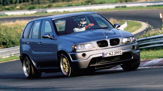 BMW X5 met V12-motor uit Le Mans-racer rijdend schuin voor circuit