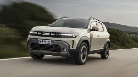 Dacia Duster Hybrid 140 Extreme grijs (2025) zijkant links schuin voor rijdend op weg