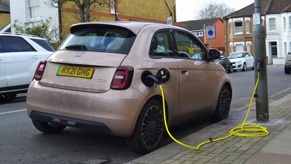 Fiat 500e opladen schuin achter vieze auto