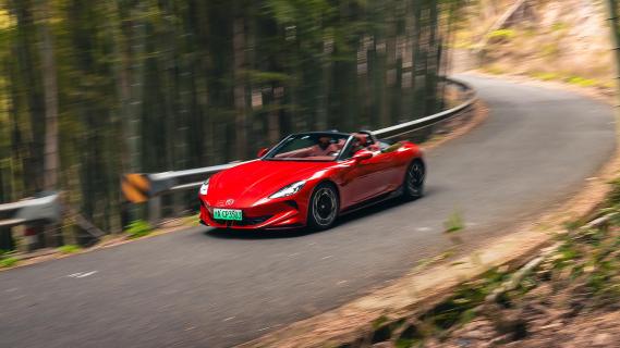 MG Cyberster rechtsvoor rijdend bergweg bossen