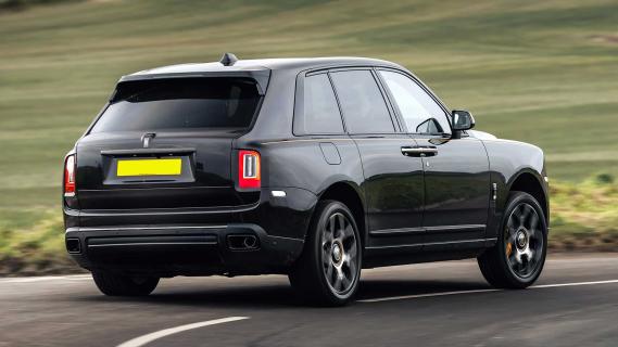 Rolls-Royce Cullinan rijdend schuin achter bocht