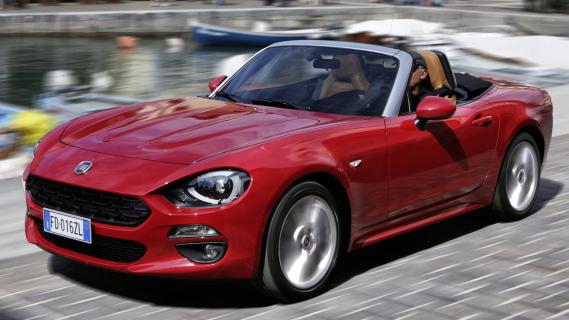 Fiat 124 Spider links voor schuin rijdend door stad