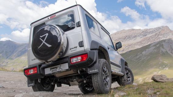 Suzuki Jimny Mata (2024) grijs zijkant achter rotsen