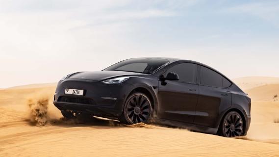 Tesla Model Y zwart zijkant rechts voor schuin zand woestijn